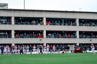 Fans crowded into a parking lot across the field to watch the game, despite it being 12 degrees at the start. 